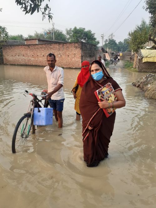एनम साक्षी शुक्ला का सराहनीय कार्य बाढ़ के पानी में जाकर किया कोविड टीका करण।